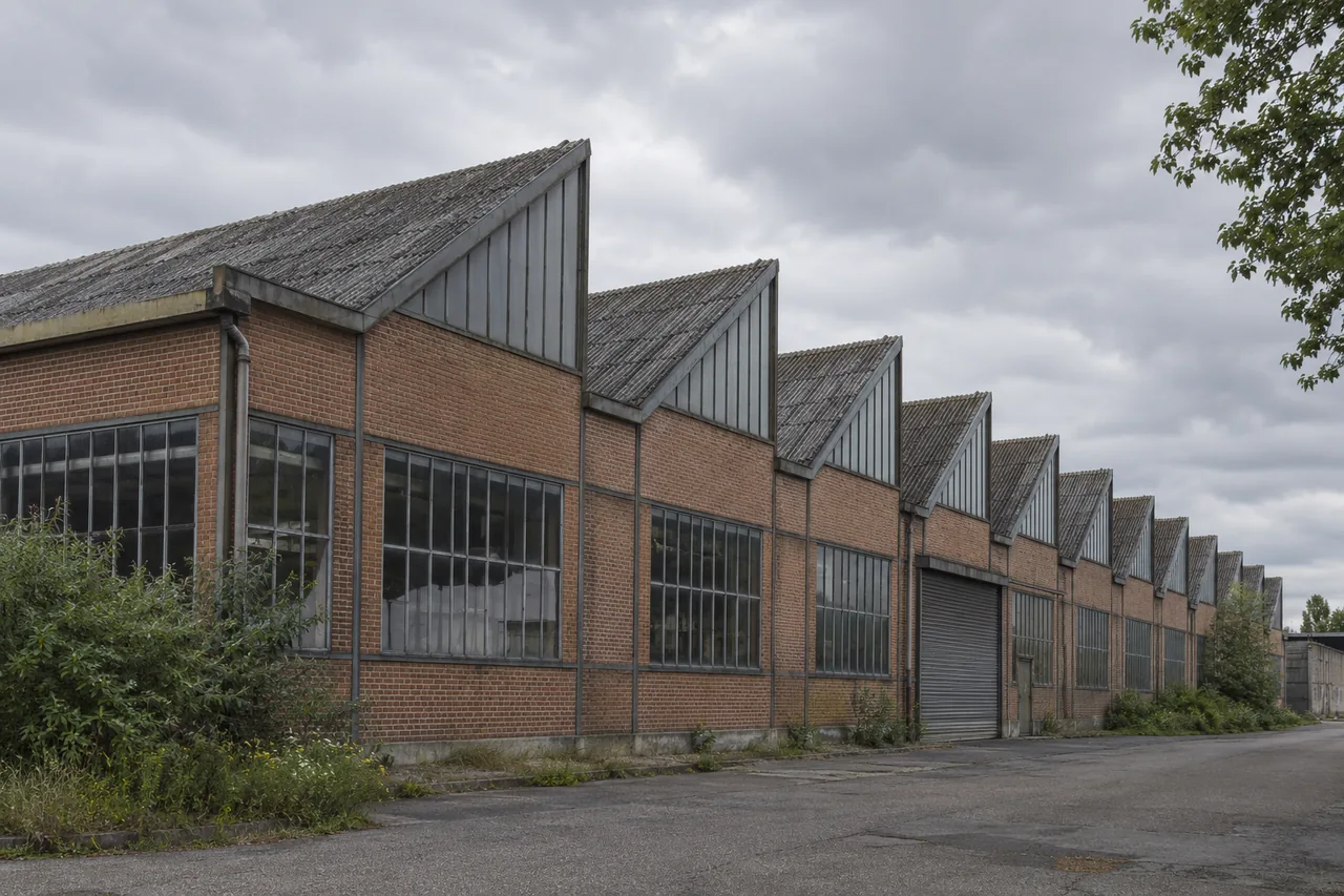 Façade en briques d’un bâtiment industriel avec toitures successives en dents de scie